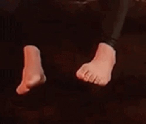 A Close Up Of A Person 'S Feet In A Dark Room With Red Lights . GIF