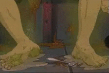 A Close Up Of A Person 'S Feet Standing On A Dirty Floor . GIF