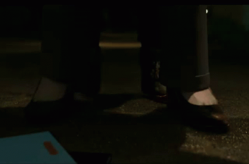 a close up of a person 's feet standing on the ground at night .