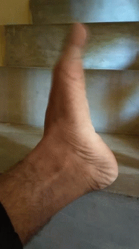 A Close Up Of A Person 'S Foot Against A Staircase GIF
