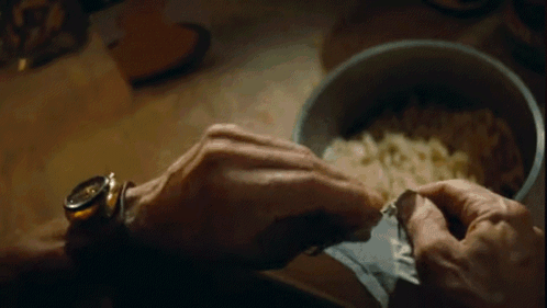 A Close Up Of A Person 'S Hand Holding A Bowl Of Food . GIF