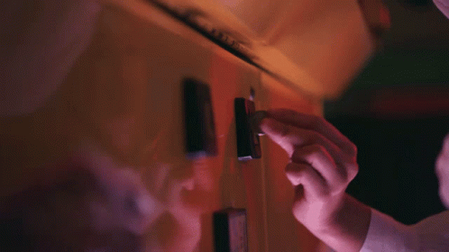 A Close Up Of A Person 'S Hand Holding A Lighter In A Dark Room GIF