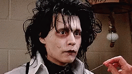 A Close Up Of A Person 'S Hand Holding A Needle To A Man 'S Face . GIF