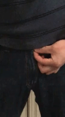 A Close Up Of A Person 'S Hand Holding A Zipper On A Pair Of Jeans GIF