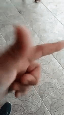 A Close Up Of A Person 'S Hand Making A Peace Sign On A Tile Floor . GIF