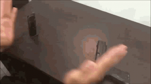 A Close Up Of A Person 'S Hand Reaching For Something On A Table GIF