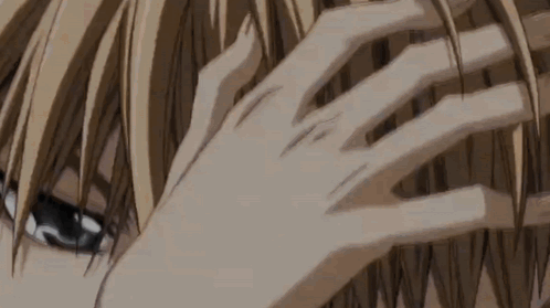A Close Up Of A Person 'S Hand Touching Their Hair . GIF
