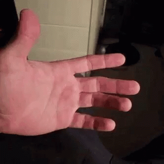 a close up of a person 's hand with their fingers outstretched and a black background .