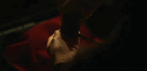 a close up of a person 's hands holding a pair of knitting needles