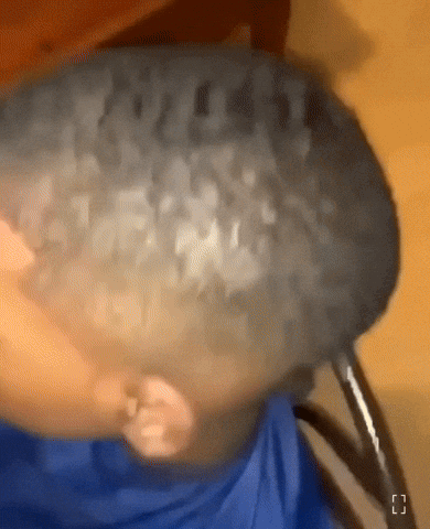 A Close Up Of A Person 'S Head With A Blue Shirt On GIF