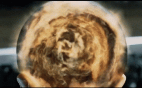 A Close Up Of A Person 'S Head With A Sphere Of Fire Coming Out Of It GIF