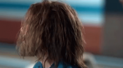 A Close Up Of A Person 'S Head With Wet Hair And A Blue Shirt . GIF