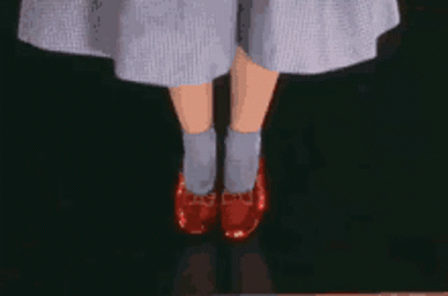 A Close Up Of A Person 'S Legs Wearing A Pair Of Red Shoes GIF