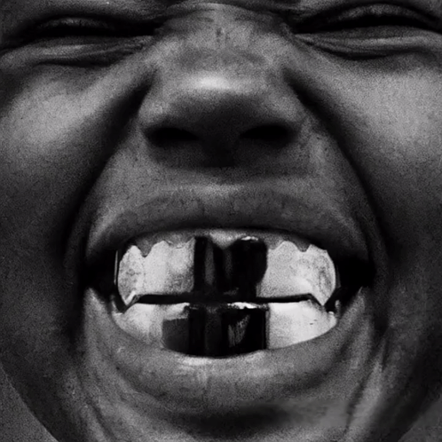 A Close Up Of A Person 'S Mouth With A Cross In The Middle Of It GIF