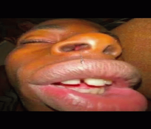 A Close Up Of A Person 'S Mouth With A Piercing In It And Their Tongue Sticking Out . GIF