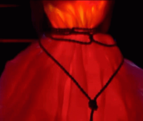 A Close Up Of A Person 'S Neck With A Red Light Behind It . GIF