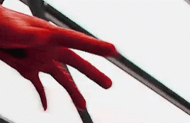 A Close Up Of A Person 'S Red Hand Reaching Out Towards A White Background . GIF