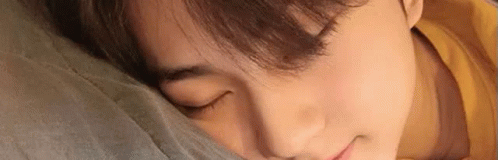 A Close Up Of A Person Sleeping On A Bed With Their Eyes Closed . GIF