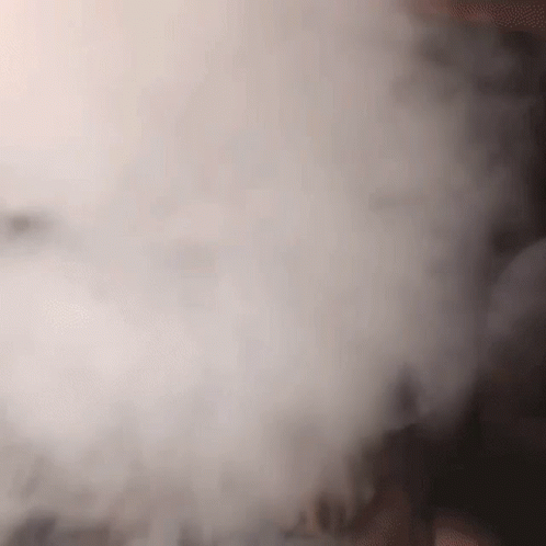 A Close Up Of A Person Smoking A Hookah With Smoke Coming Out Of It GIF