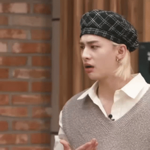 A Close Up Of A Person Wearing A Beret And A Sweater Vest . GIF