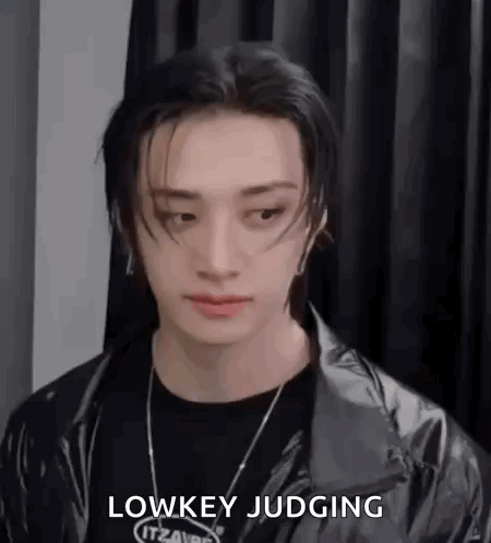 A Close Up Of A Person Wearing A Black Jacket And A Black Necklace . GIF