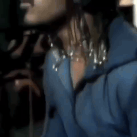 a close up of a person wearing a blue jacket and a black hat .