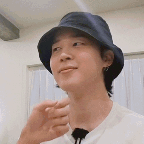A Close Up Of A Person Wearing A Bucket Hat And Earrings . GIF