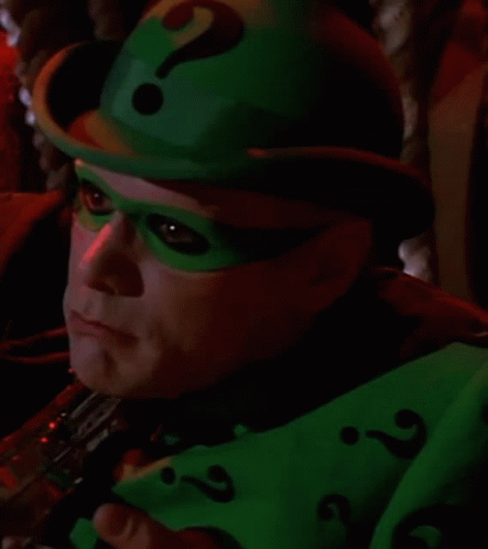 A Close Up Of A Person Wearing A Green Hat And Mask With A Question Mark . GIF