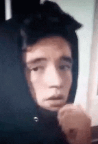 A Close Up Of A Person Wearing A Hoodie With A Hood On Their Head . GIF