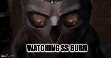 A Close Up Of A Person Wearing A Mask With The Words `` Watching Ss Burn '' Written Above It . GIF