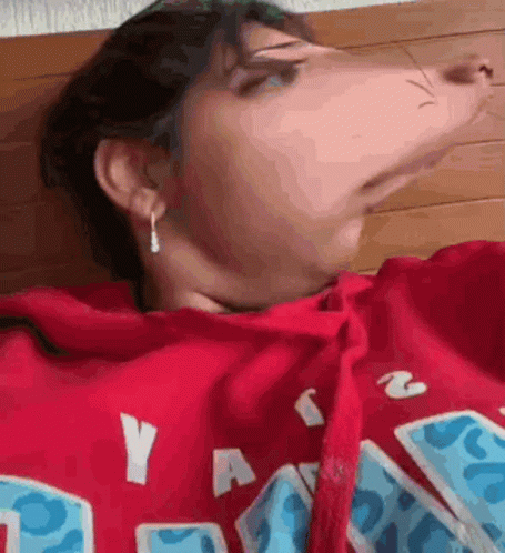 a close up of a person wearing a red hoodie .