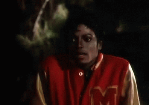 A Close Up Of A Person Wearing A Red Jacket With The Letter M On It GIF