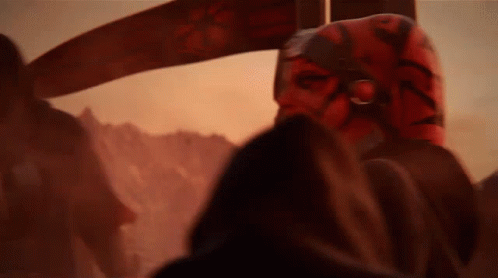A Close Up Of A Person Wearing A Red Mask In A Dark Room . GIF