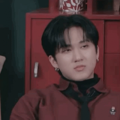 A Close Up Of A Person Wearing A Red Shirt And Tie Making A Funny Face . GIF