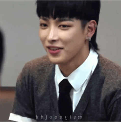 A Close Up Of A Person Wearing A Sweater And Tie GIF