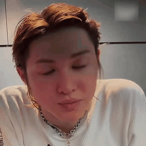 A Close Up Of A Person Wearing A White Shirt And A Chain GIF