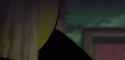 a close up of a person wearing a yellow hat in a dark room