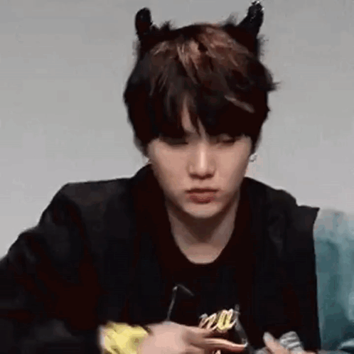 A Close Up Of A Person Wearing Devil Horns And A Black Jacket . GIF