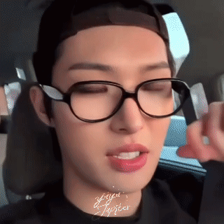 A Close Up Of A Person Wearing Glasses And A Black Shirt GIF