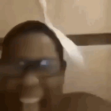 A Close Up Of A Person Wearing Glasses And A Hat In A Bathroom . GIF