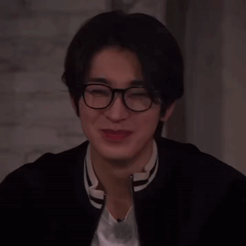 A Close Up Of A Person Wearing Glasses And A Jacket GIF