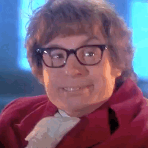 A Close Up Of A Person Wearing Glasses And A Red Coat GIF
