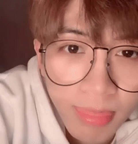 A Close Up Of A Person Wearing Glasses And A White Sweatshirt . GIF