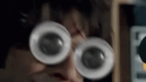 A Close Up Of A Person Wearing Glasses With Big Eyes . GIF