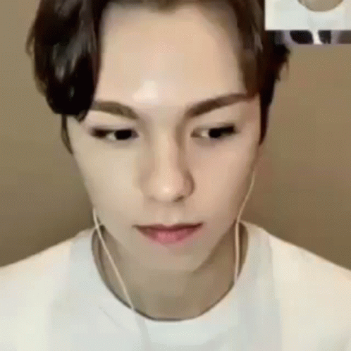 A Close Up Of A Person Wearing Headphones And A White T-Shirt . GIF