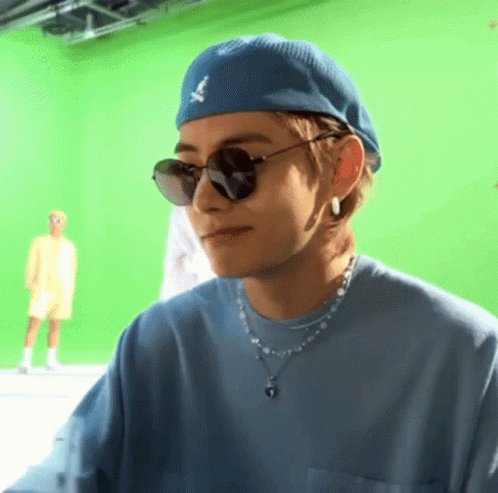 A Close Up Of A Person Wearing Sunglasses And A Blue Hat . GIF