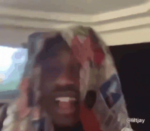 A Close Up Of A Person With A Scarf On Their Head GIF