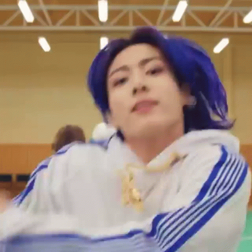 A Close Up Of A Person With Blue Hair Wearing A White And Blue Sweatshirt . GIF