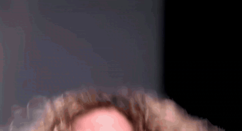 A Close Up Of A Person With Curly Hair GIF