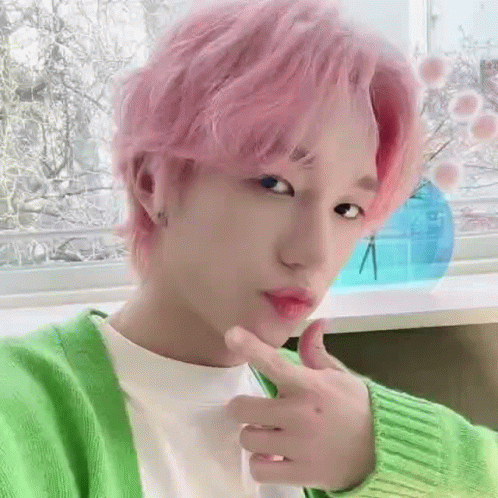 A Close Up Of A Person With Pink Hair Wearing A Green Sweater . GIF